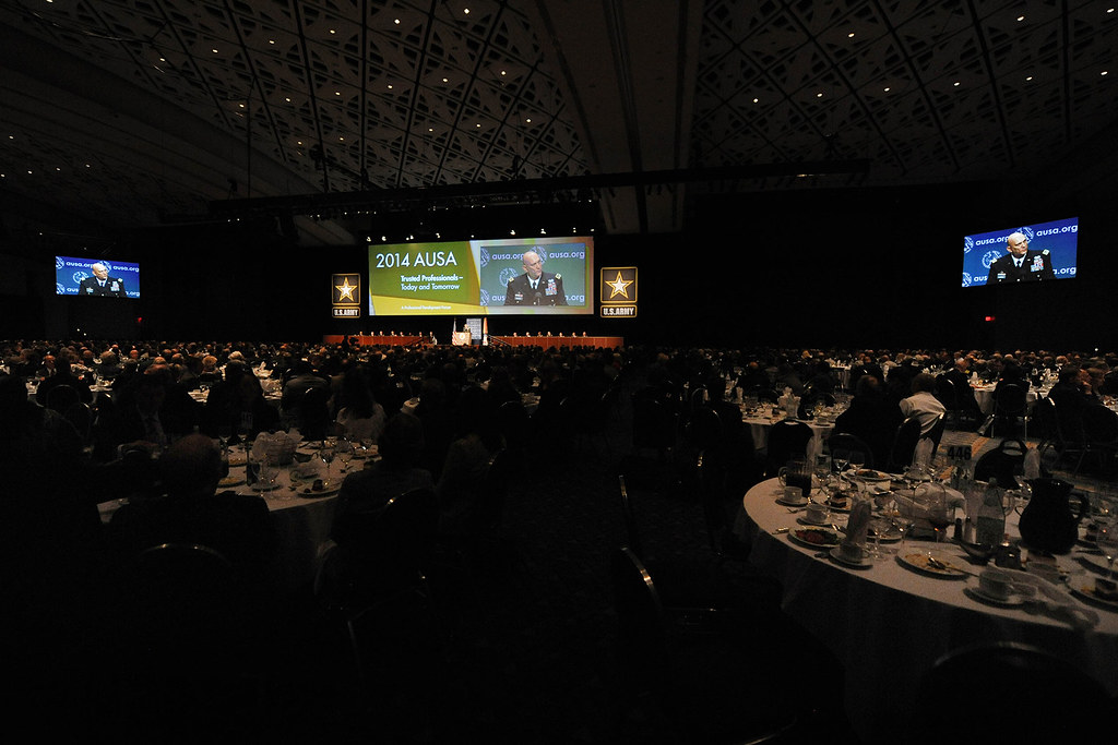 Keynote speaker on a conference stage in front of a large audience